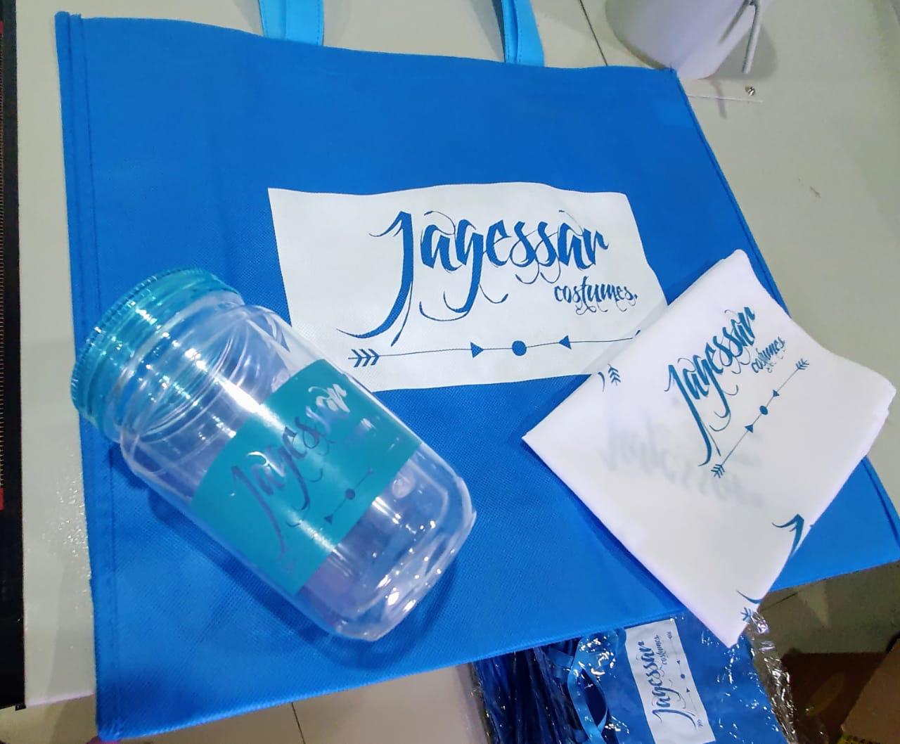 Blue bag, clear tumbler and white fabric item with matching blue and white branding.