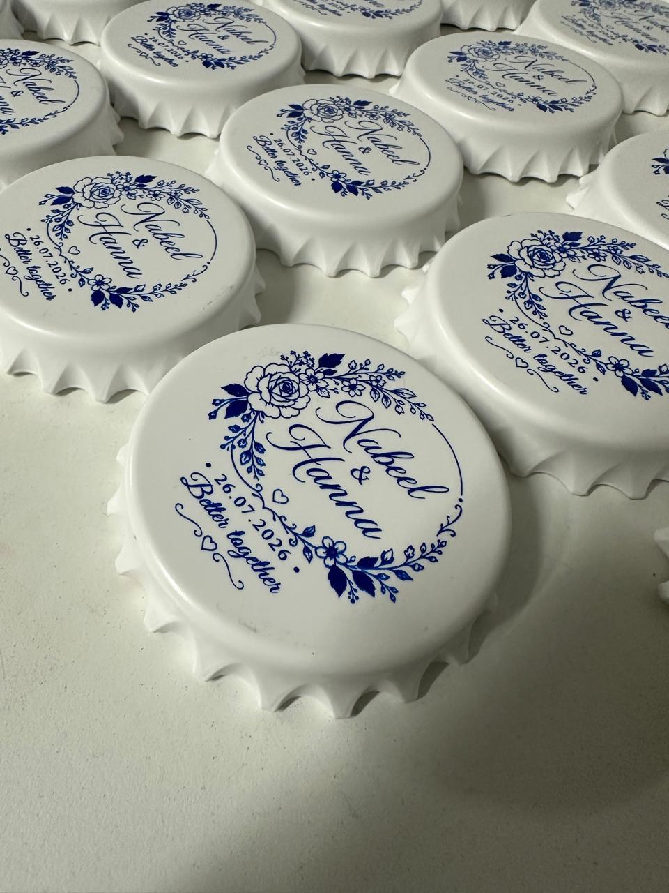 White scalloped round pieces with blue floral designs, names and a date.